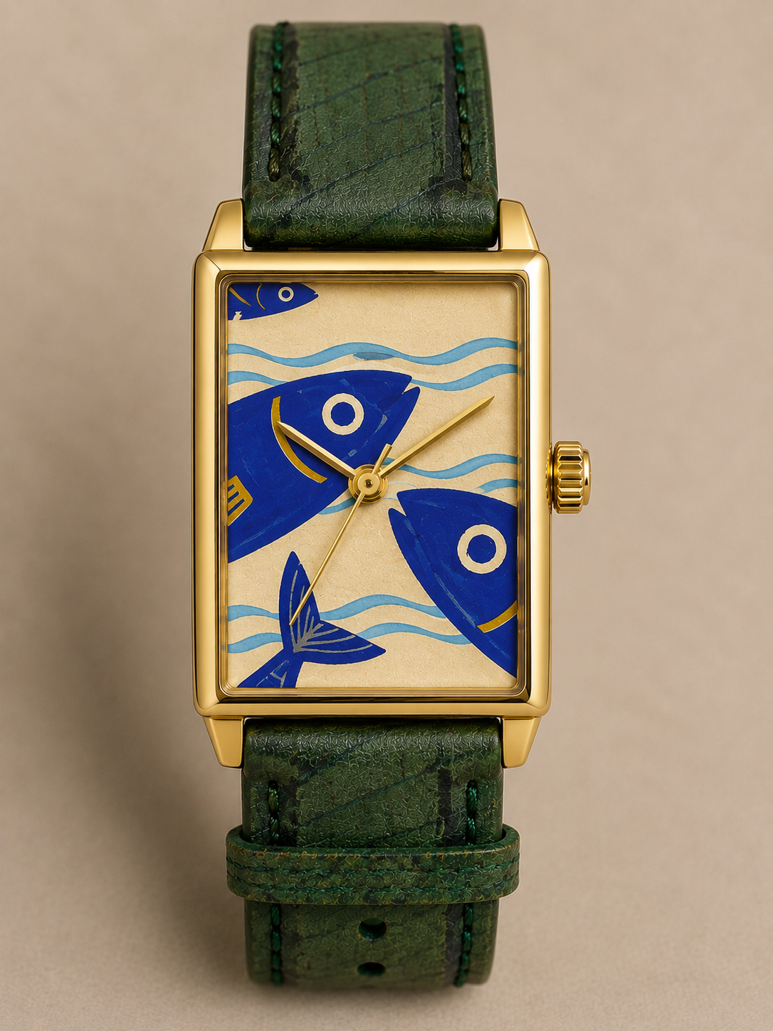 Coqueiro, conceito PP Atelier com peixes azuis sobre mostrador bege, caixa dourada e pulseira verde.