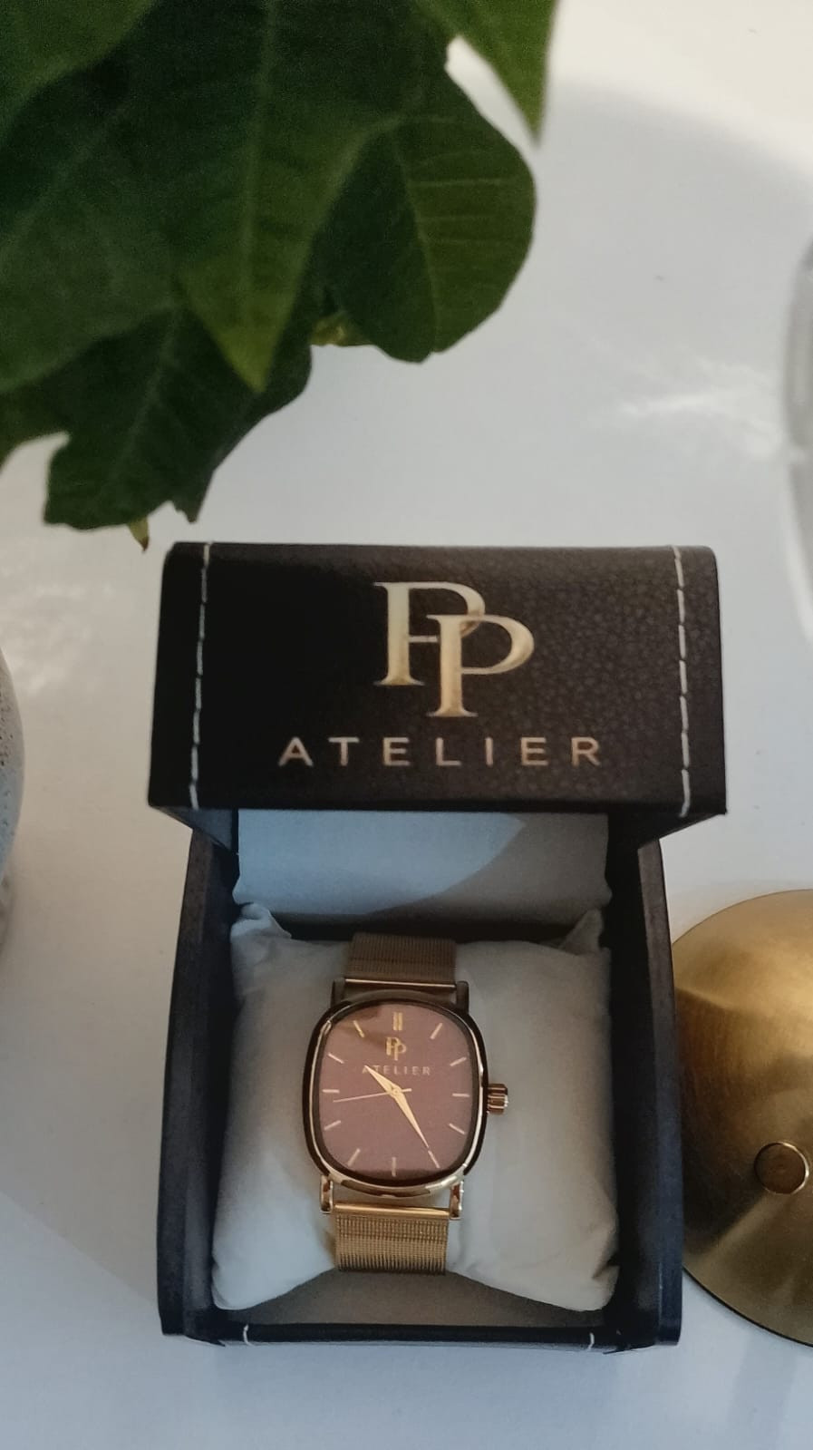 PP Atelier Suede em sua caixa personalizada, com mostrador rosado, caixa dourada e pulseira milanesa dourada.